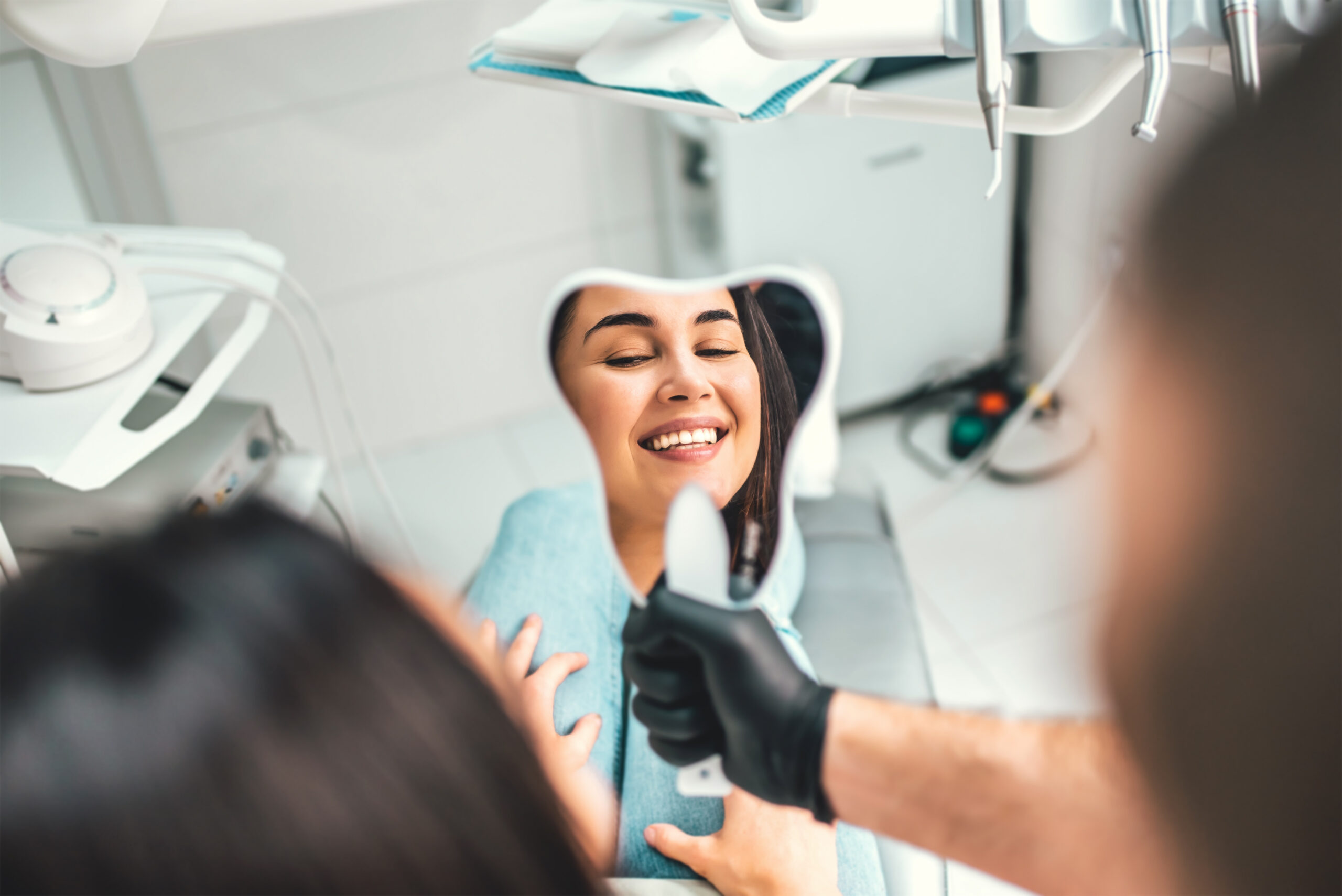 Paciente observando su sonrisa durante consulta odontológica en clínica moderna EVVOCA.